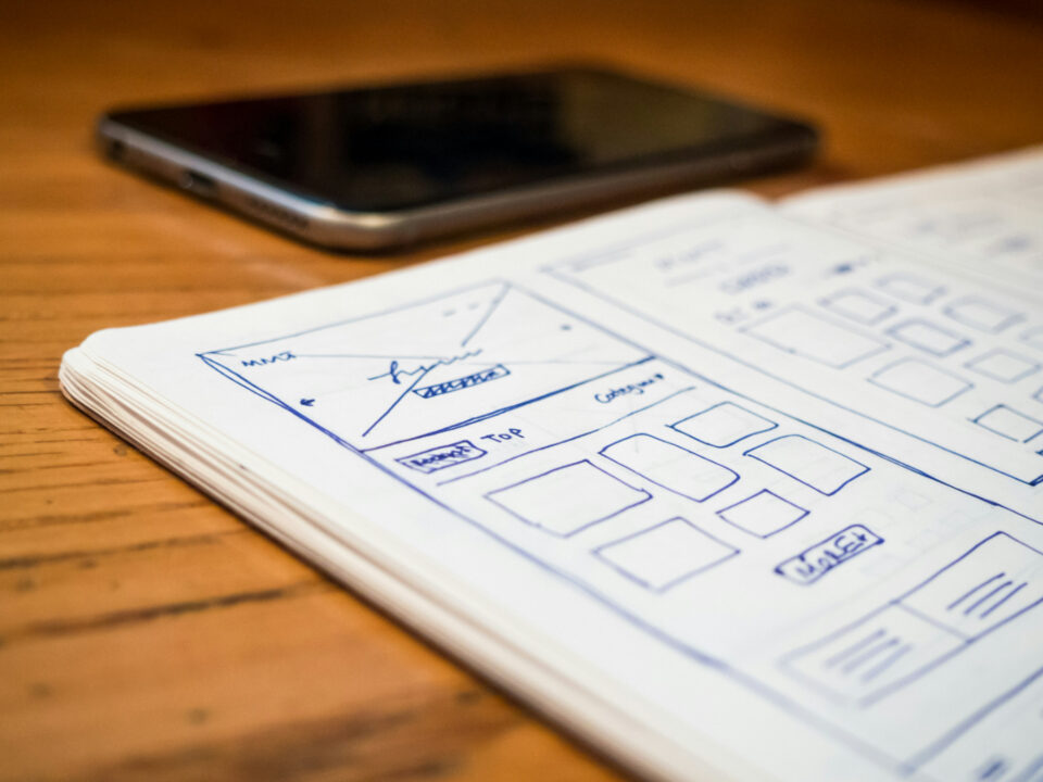 Interface design interface wireframes sketched beside a smartphone