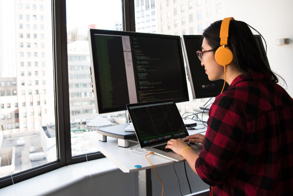 developer working at a multi-monitor code setup