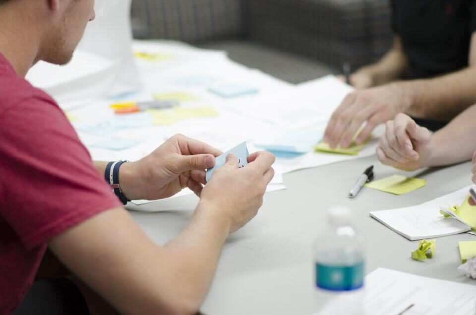 team collaborating around a table with sticky notes